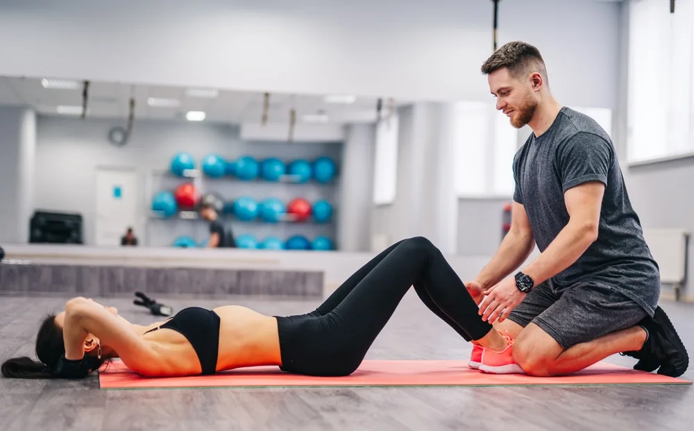 A coach mobilising a client's leg on the training floor