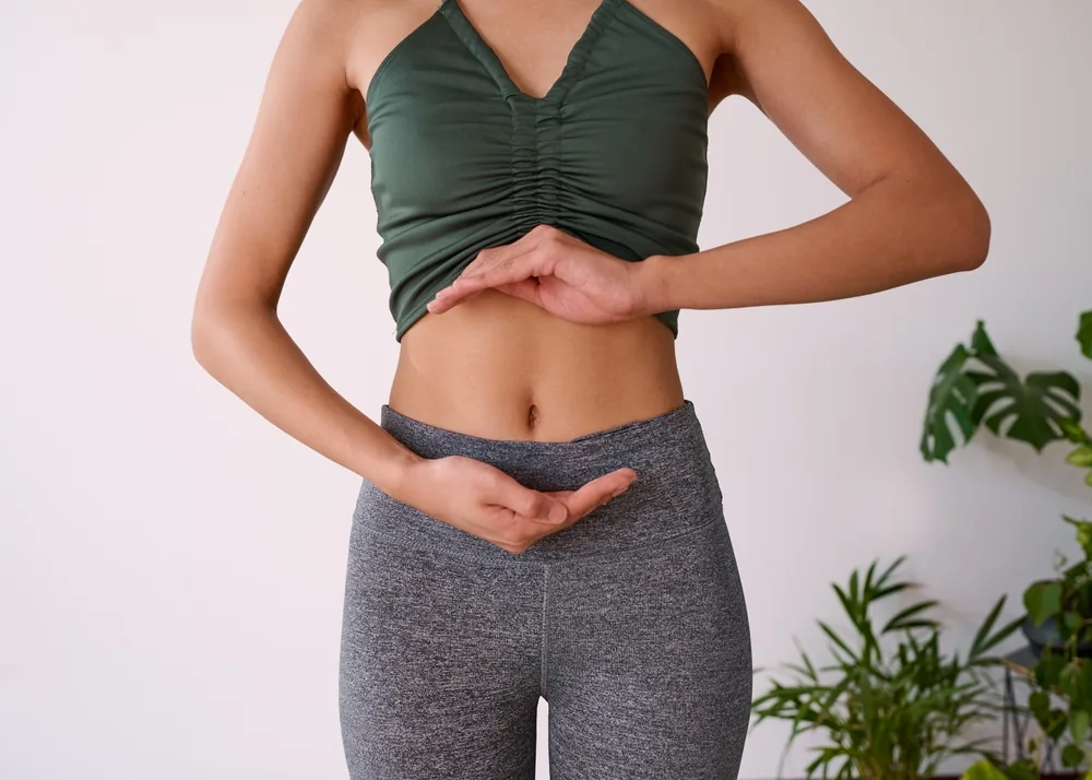 Hands resting low over the abdomen